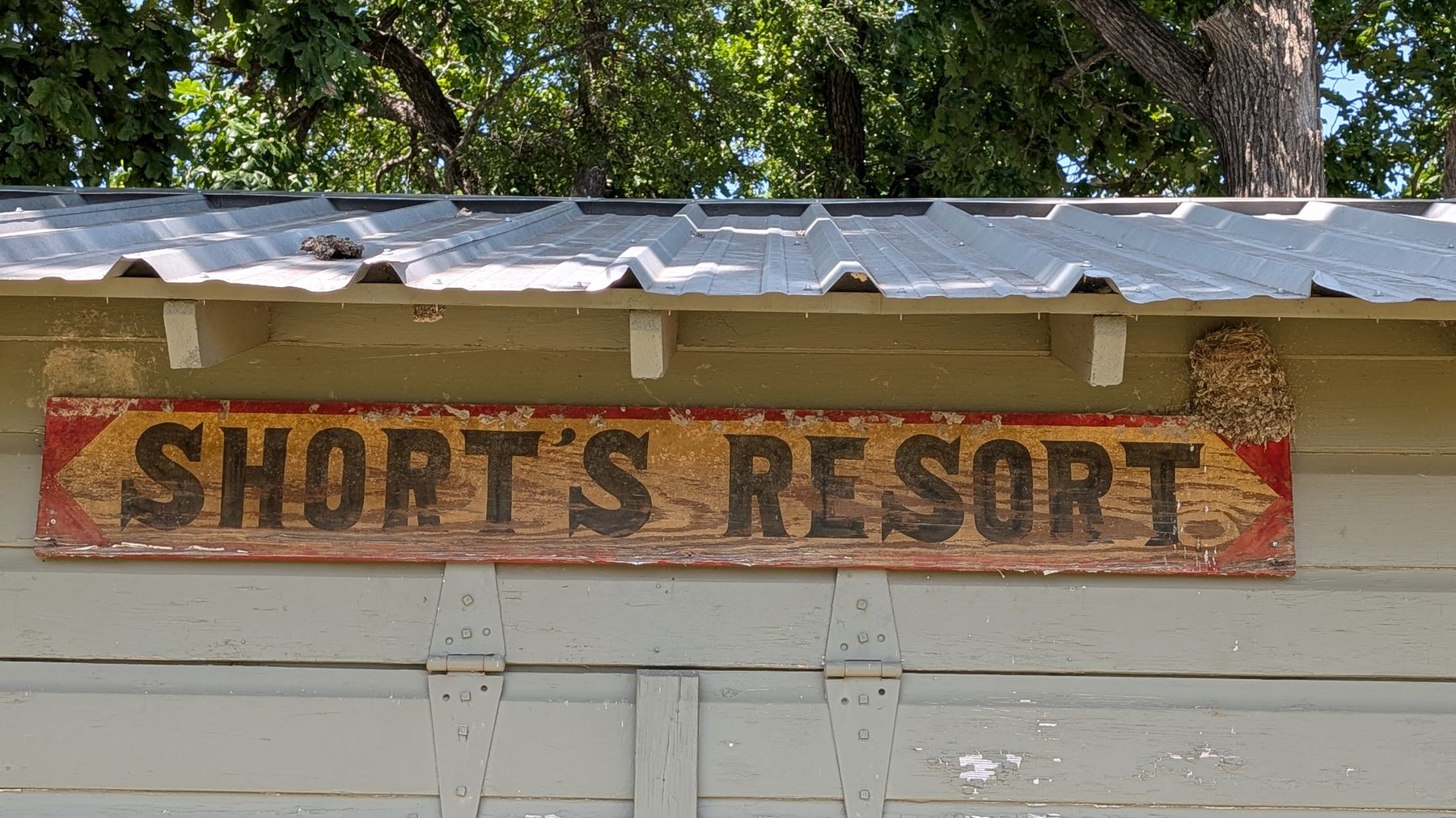 The original hand-painted Short’s Resort sign under the cabin’s tin roofline